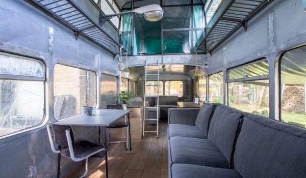 Binnenkant van een dubbeldekker bus waar je bijzonder kunt overnachten